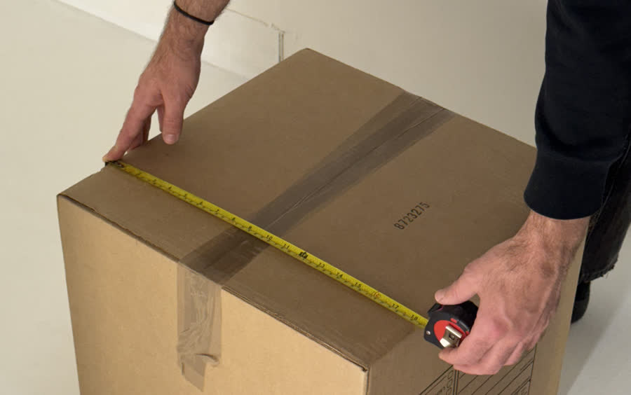 Person measures cardboard box